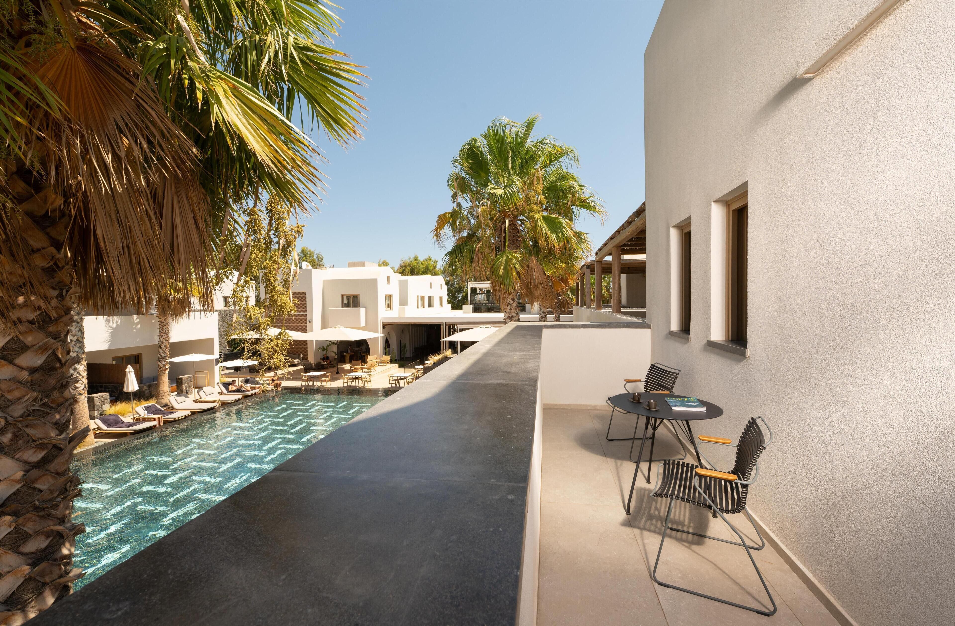 A poolside area with lounge chairs, a small table, and a clear view of the pool.