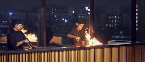 Un restaurante con zona de bar, paneles de madera y vistas a la ciudad.