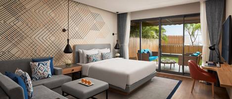 A modern hotel room with a large bed, a sofa, a desk, and a balcony with a view.