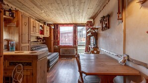 Een houten interieur met een eetgedeelte, inbouwzitplaatsen en een keuken met houten kastjes.