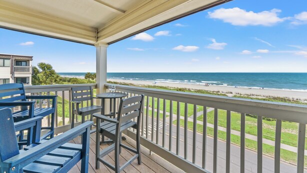 Ein Balkon mit Blick auf Strand und Meer.