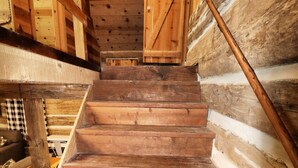 Una escalera de madera en el interior de una cabaña de troncos.