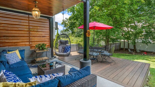 A covered patio with outdoor furniture, a hanging chair, and a table. - Next to Boston & Beach, King Beds, Free Parking+EV (Quincy)