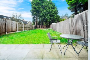 A backyard with a wooden fence, a grassy lawn, and a patio area with a table and chairs. - 3bed house, in close proximity to the centre suitable for 6 guests!Pet-Friendly! (West Midlands)