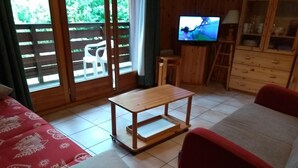 A cozy living room with a wooden coffee table, a sofa, and a television on a wooden cabinet. - Clos des Loirs, 6. 55m2 duplex apartment, not overlooked (Samoëns)