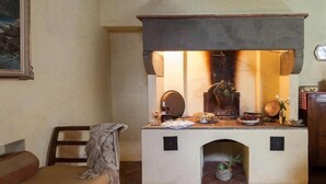 Una stanza accogliente con un camino, una panca e un tavolo con diversi oggetti.