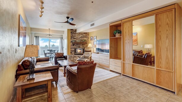 A spacious living room with a fireplace, leather furniture, and a large wooden cabinet. - Lodge at Mtn Village B148 | Ski-In/Out | Valley View | Washer/Dryer | Pool | Hot Tub (Park City)