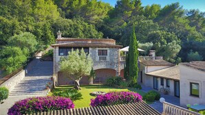 A stone villa with a terracotta roof, surrounded by lush greenery and a well-maintained garden with vibrant flowers. - Llobarro, Villa-Finca 5StarsHome Mallorca (Pollensa / Pollença)