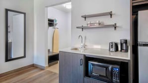 A modern kitchen with a built-in microwave, a sink, and a coffee maker on the countertop. - Studio 6 Georgetown, KY – Lexington North (Georgetown)
