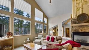A spacious living room with large windows, a fireplace, and a cozy seating area. - Free SkyCard Act-Home, Private Hot Tub, Perfect For Large Families-Gold King Cha (Breckenridge)