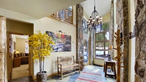 A spacious foyer with a large window, a chandelier, a wooden bench, and a patterned rug. - Free SkyCard Act-Home, Private Hot Tub, Perfect For Large Families-Gold King Cha (Breckenridge)