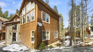 A two-story wooden cabin with large windows, a stone foundation, and a satellite dish. - Free SkyCard Act-Home, Private Hot Tub, Perfect For Large Families-Gold King Cha (Breckenridge)
