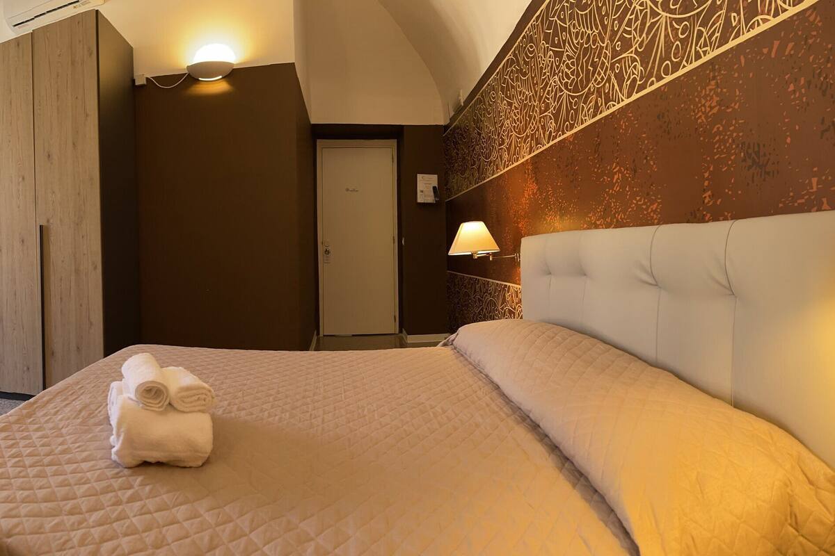 Una habitación de hotel con una cama, un escritorio, una silla y un televisor.