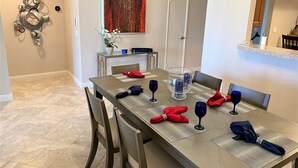 A dining area with a long table set for four, including place settings, napkins, and wine glasses. - Palm Valley CC Remodeled beauty, 2b 2ba on 6th fairway w/golf cart, club access. (Palm Desert)