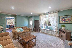 A living room with a sofa set, a coffee table, a cabinet, and a window with curtains. - Castle Rock in Big Bear (Big Bear)