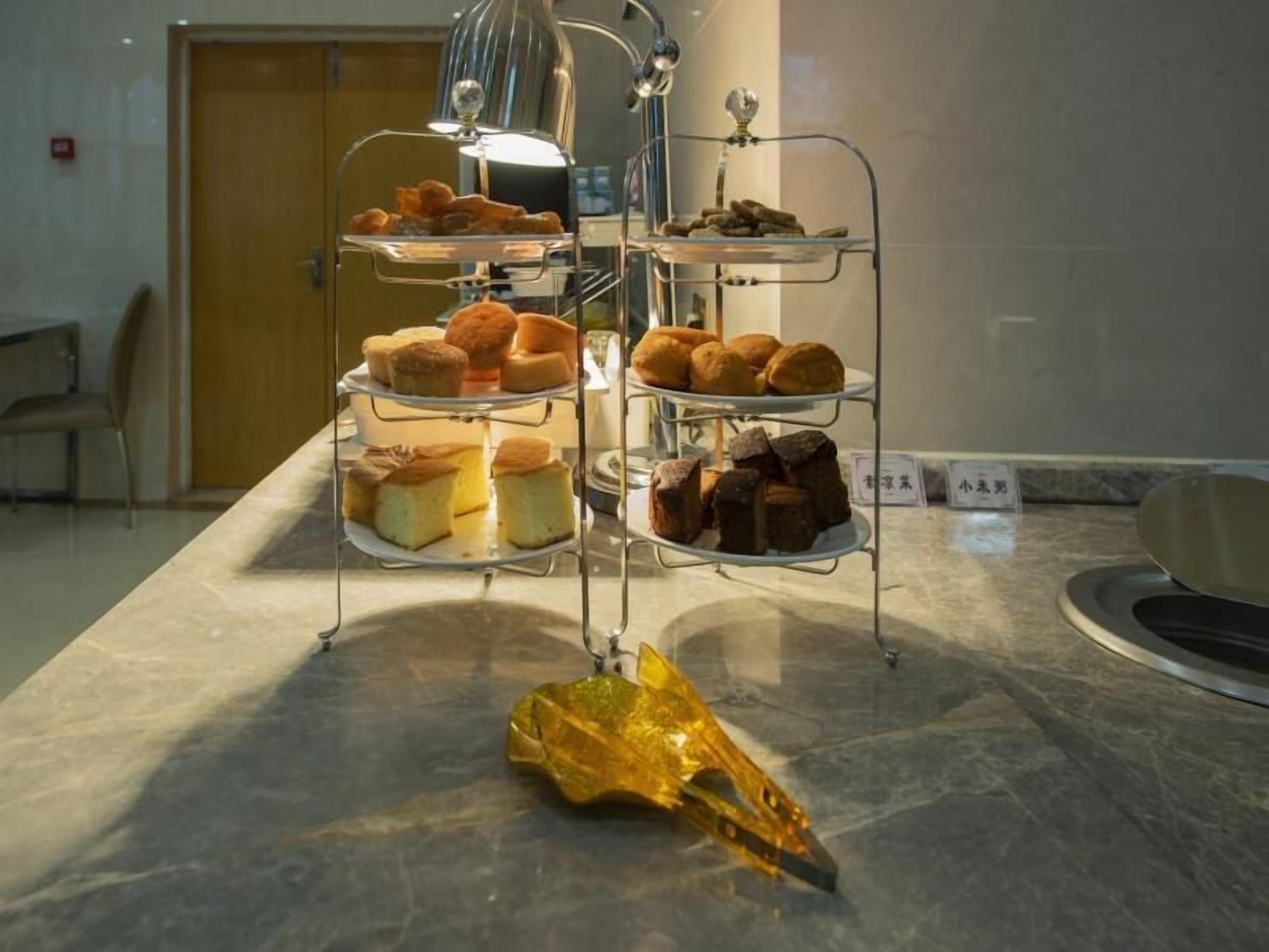 A three-tiered display stand with various baked goods in a hotel setting.