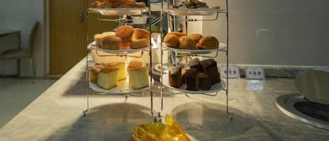 A three-tiered display stand with various baked goods in a hotel setting.