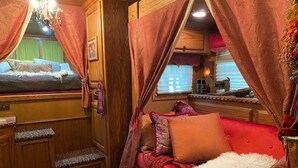 Un intérieur chaleureux avec un canapé rouge, un meuble en bois et une fenêtre agrémentée de rideaux.