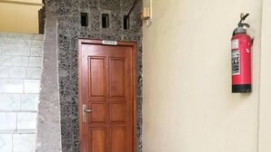 A wooden door labeled "OFFICE" with a fire extinguisher mounted on the wall to the right. - OYO 3902 Pondok 828 Residence (Denpasar)
