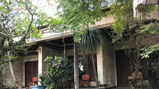 A covered outdoor area with steps leading up to a building entrance, surrounded by potted plants and trees. - OYO 3902 Pondok 828 Residence (Denpasar)