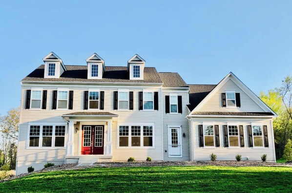 Stunning two-story home with a central entrance and dormer windows.