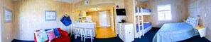 Cozy retreat with a single bed, compact kitchenette, and comfortable seating area.
