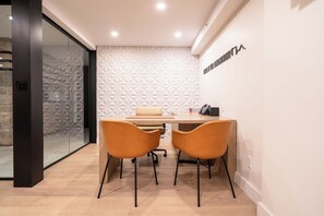 A modern office space with a glass partition, a patterned wall, and a desk with two chairs. - Charming Corner Condo, fireplace, spa access, two steps to Vail Village and Lifts (Vail)