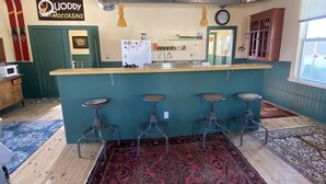 A kitchen with a bar area, wooden stools, a patterned rug, and a sign on the wall. - Spacious Loft in Downtown Lewiston  (Lewiston)