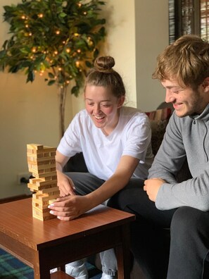 Deux personnes jouent à un jeu de construction avec des blocs en bois sur une table.