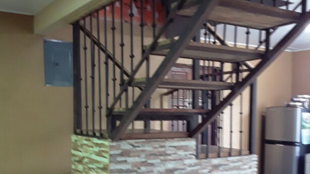 Un escalier avec un mur d’accent en pierre et des rampes en métal.
