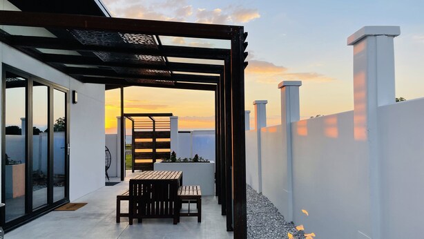 A modern outdoor patio with a pergola, a fire pit, and a seating area. - Private modern luxury vacation rental (Stockton)