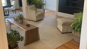 A modern living room with a sofa, armchairs, a coffee table, and potted plants. - Victorian Home near downtown, Georgian Bay and many bike & hiking trails (Collingwood)