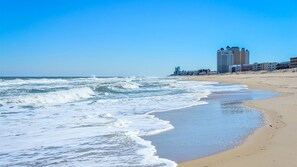 A beach with waves, a sandy shore, and buildings in the background. - 🏖️ Popular Adagio Oceanside Condo!  🏖️ (Ocean City)