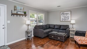 A living room with a gray sectional sofa, two side tables with lamps, a coffee table, and a framed quote on the wall. - Mid Peninsula sleeps 8. Feels like home! (Newport News)