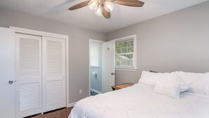 A bedroom with a bed, a ceiling fan, and a window with blinds. - Mid Peninsula sleeps 8. Feels like home! (Newport News)