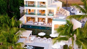 Ein mehrstöckiges Resort mit Pool, Außenbereich und üppiger Bepflanzung.