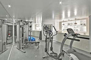 Une salle de sport moderne équipée de machines de cardio, d’appareils de musculation et d’un ballon d’exercice bleu.