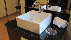 Un baño moderno con un lavamanos blanco, un espejo y una toalla.