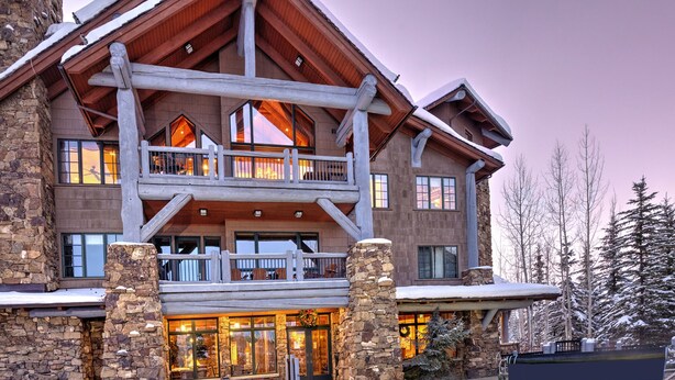 A large lodge with a pool, stone exterior, and multiple balconies.