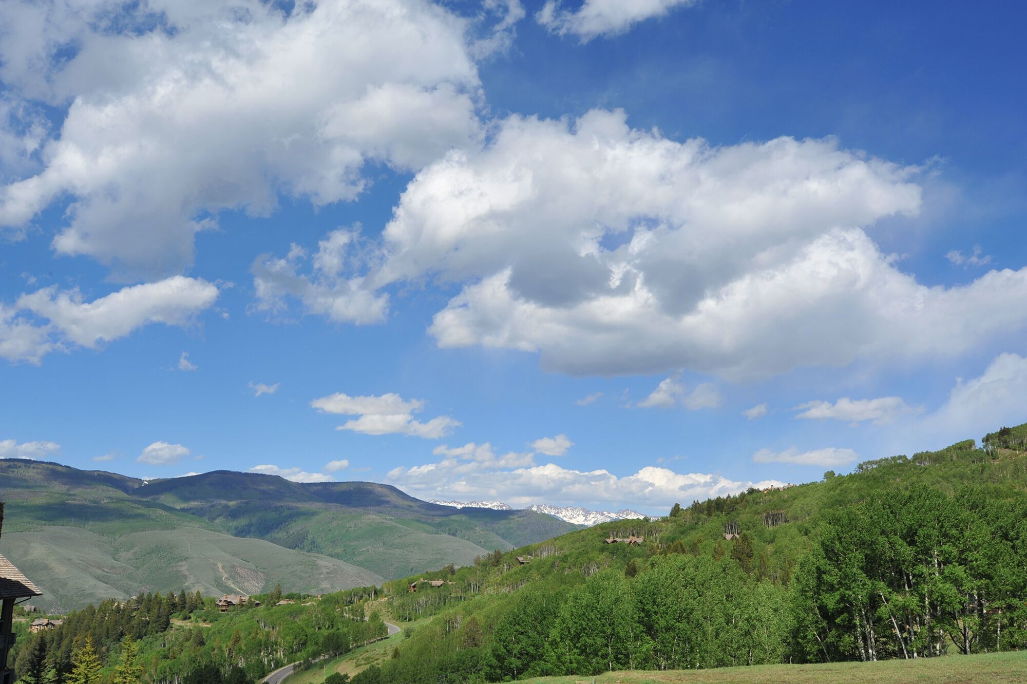 A mountainous landscape with a clear sky and scattered clouds.