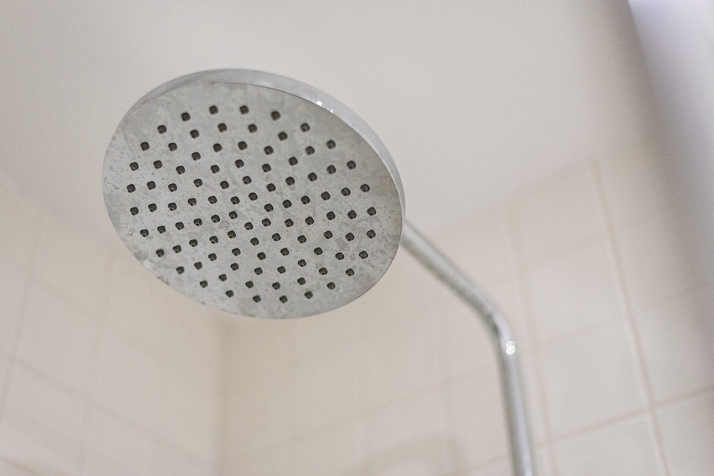 Un pommeau de douche au design circulaire et perforé.