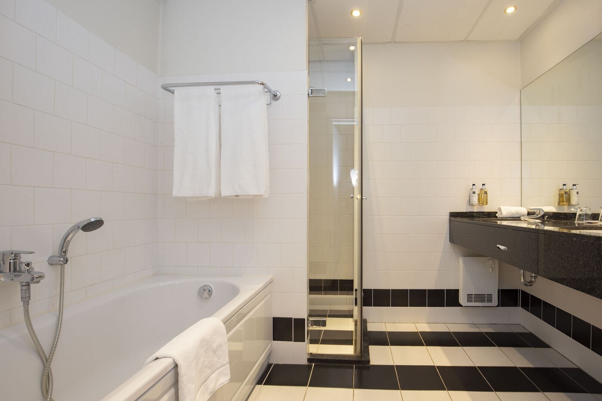Un bagno moderno con vasca, cabina doccia in vetro e lavabo con specchio.