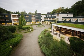 Un hôtel moderne doté d’une cour intérieure, d’un espace extérieur aménagé pour se détendre et de plusieurs étages avec des balcons.