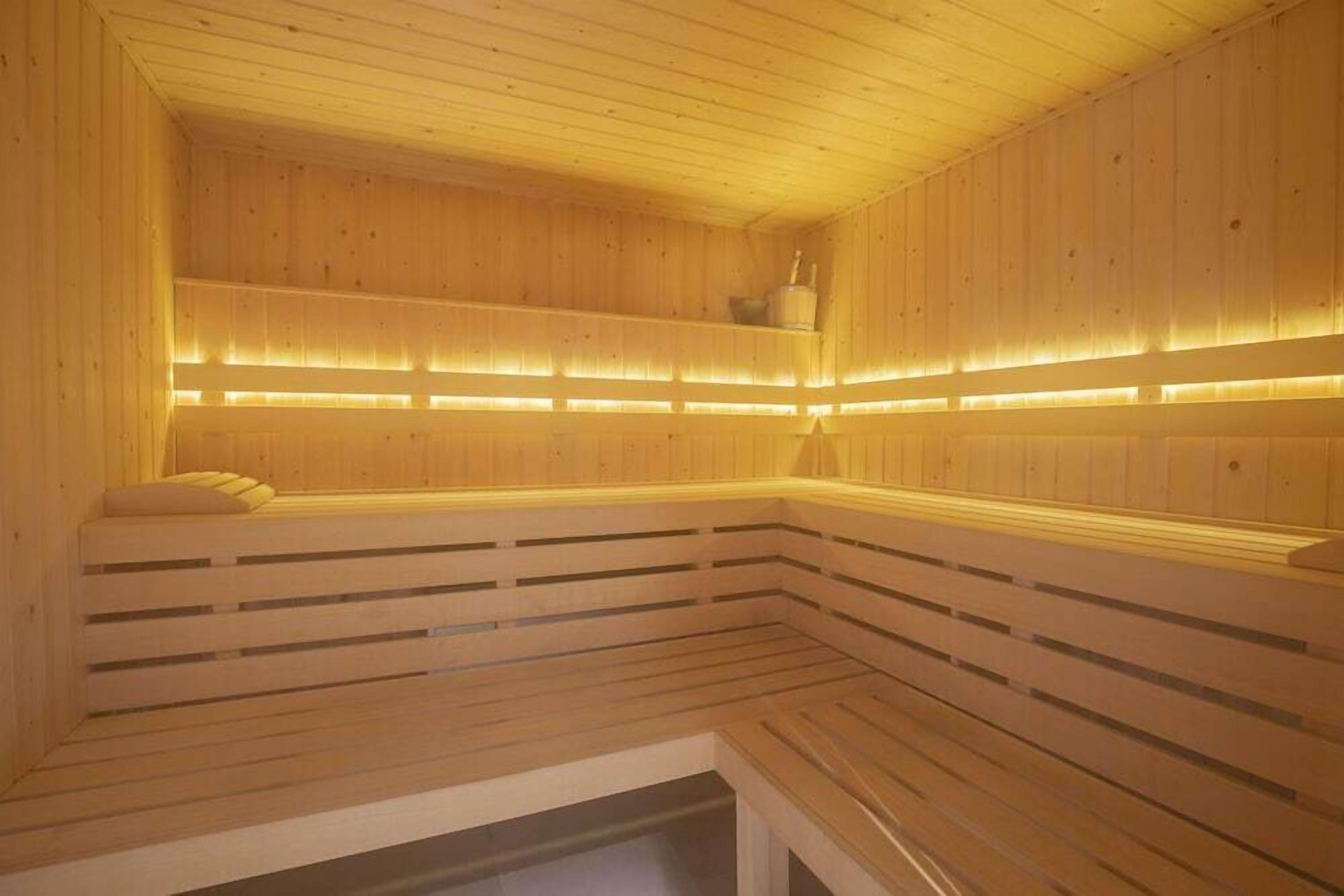 Un sauna en bois avec des bancs, et un banc situé à gauche.