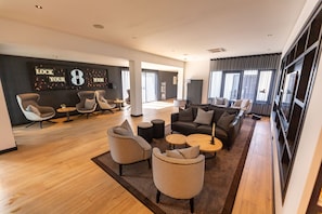A spacious hotel lobby with a modern design, featuring a mix of seating arrangements and a large wall with decorative elements. - Gr8 Hotel Sevenum (Sevenum)