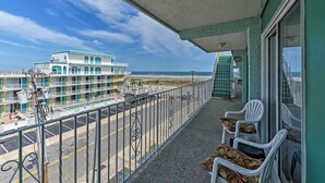 Ein Balkon mit Blick auf einen Strand und ein Hotelgebäude.