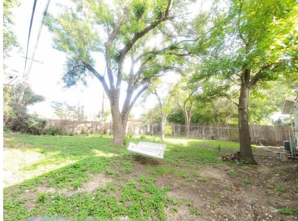 Relax in a serene outdoor space surrounded by nature, complete with a charming swing set.