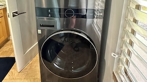 Eine moderne LG ThinQ Waschmaschine mit Edelstahloptik, einer Bedienkonsole und einer Glastür.