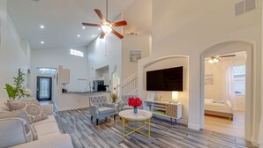 A spacious living room with a grey sofa, a round coffee table, and a ceiling fan. - Sweet Sunshine Retreat near Disney. 4 king beds. Free heated pool.  (Davenport)