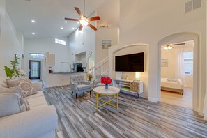 A spacious living room with a grey sofa, a round coffee table, and a ceiling fan. - Sweet Sunshine Retreat near Disney. 4 king beds. Free heated pool.  (Davenport)